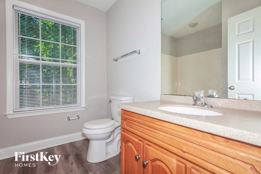 a bathroom with a toilet and a sink and a mirror