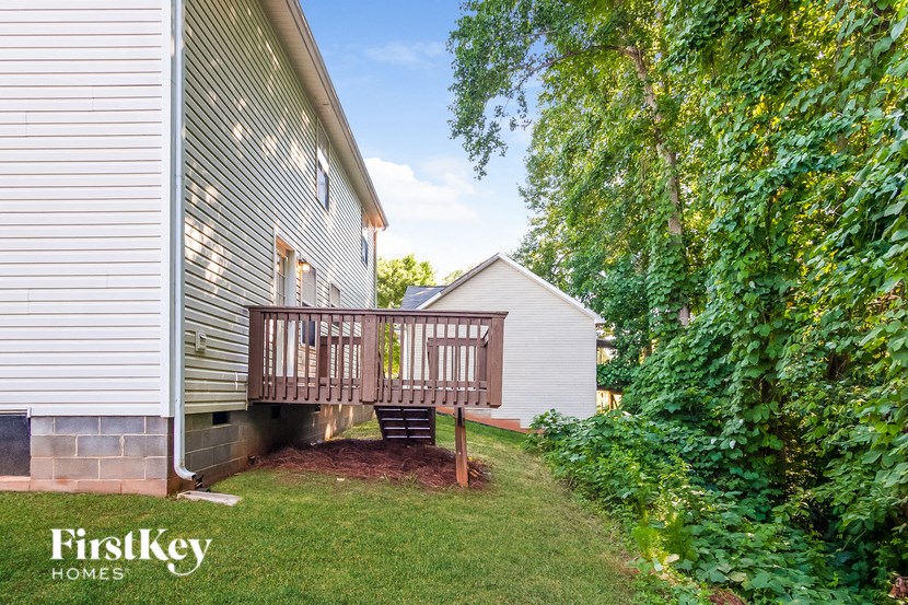 a backyard with a deck on the side of a house