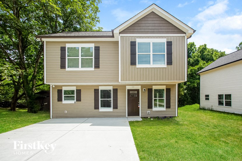 a tan house with a sidewalk in front of it