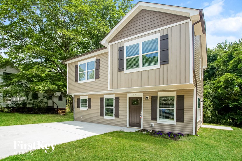 a tan house with a sidewalk in front of it