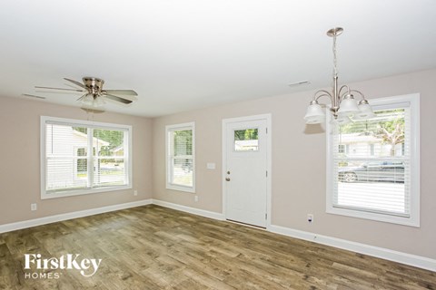 a living room with wood floors and a ceiling fan