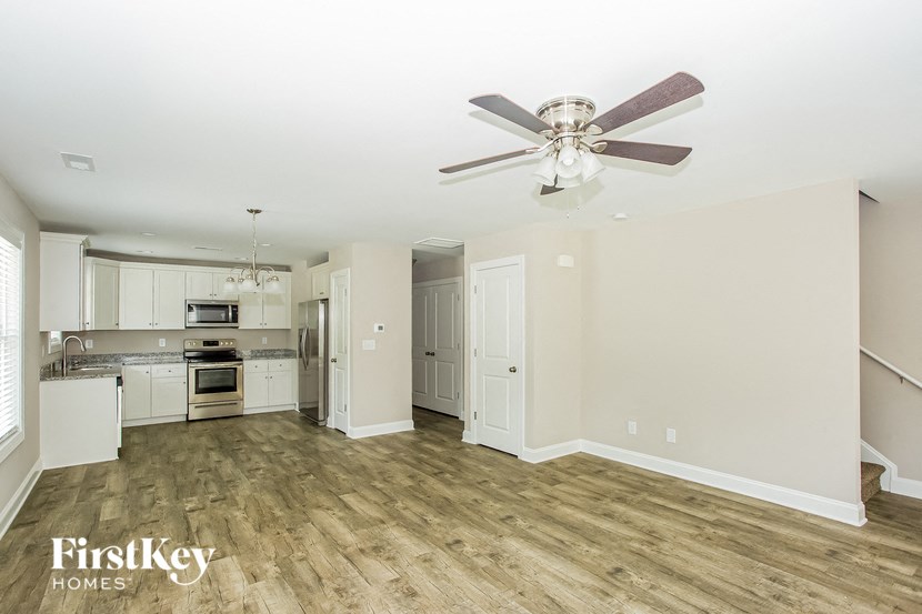 a kitchen with white cabinets and a ceiling fan