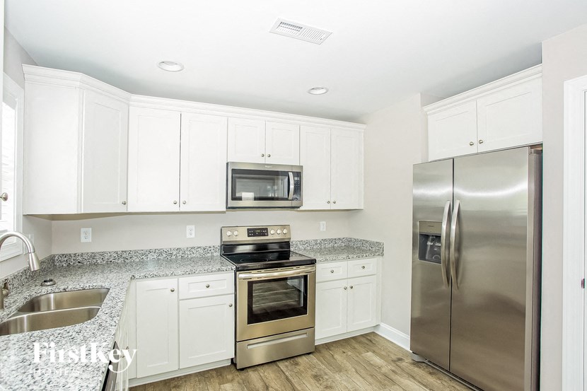 a kitchen with white cabinets and stainless steel appliances