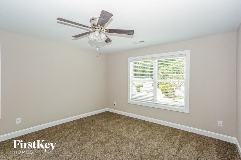 a bedroom with a ceiling fan and a window
