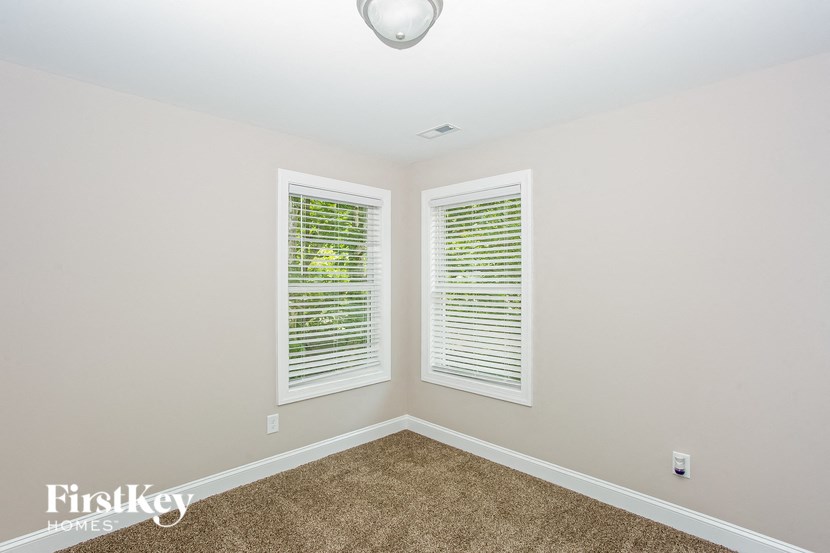 the second bedroom has two windows and a carpeted floor