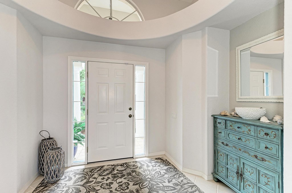 a hallway with a white door and a blue dresser with a suitcase