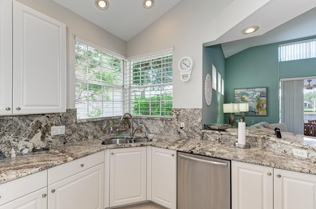 a kitchen with granite counter tops and white cabinets