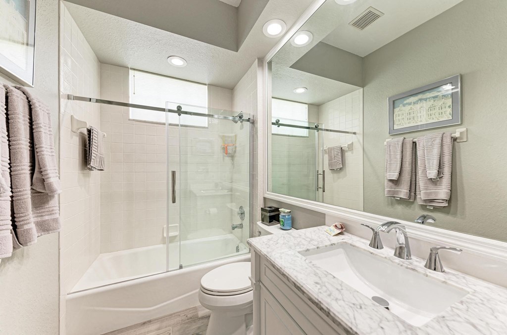 a bathroom with a shower sink and toilet and a mirror