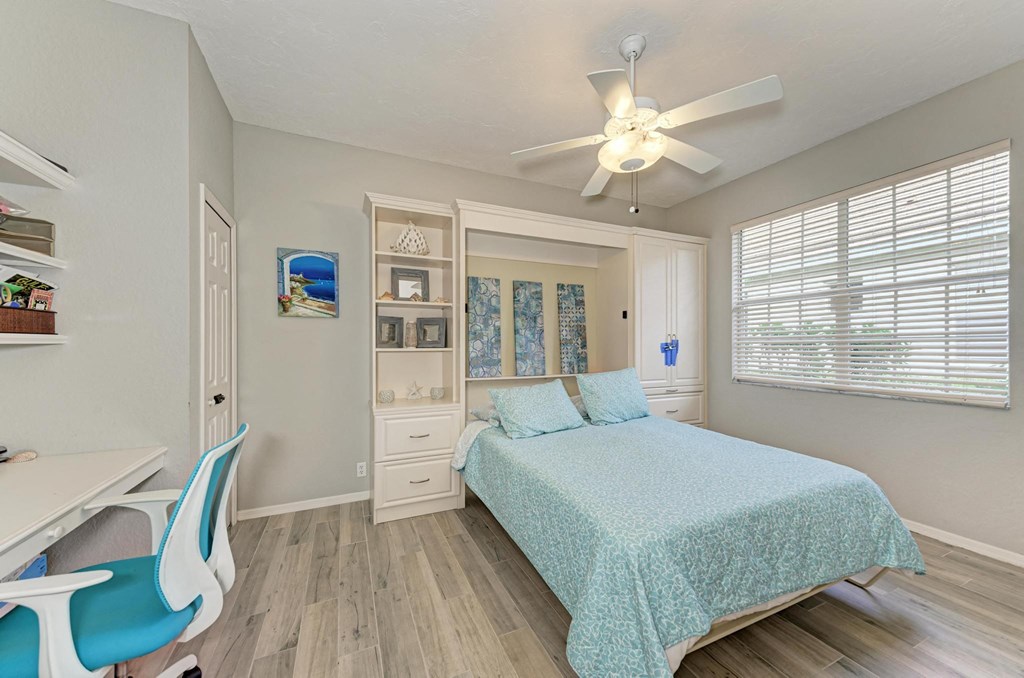 a bedroom with a bed and a ceiling fan