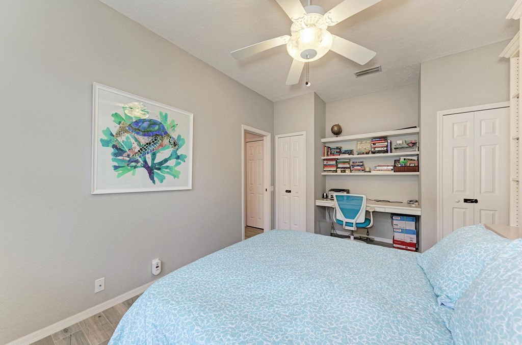 a bedroom with a large bed and a ceiling fan
