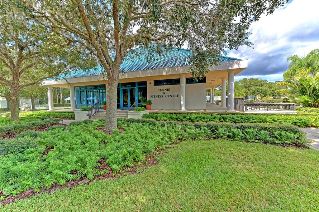 a building with a porch and a tree in front of it