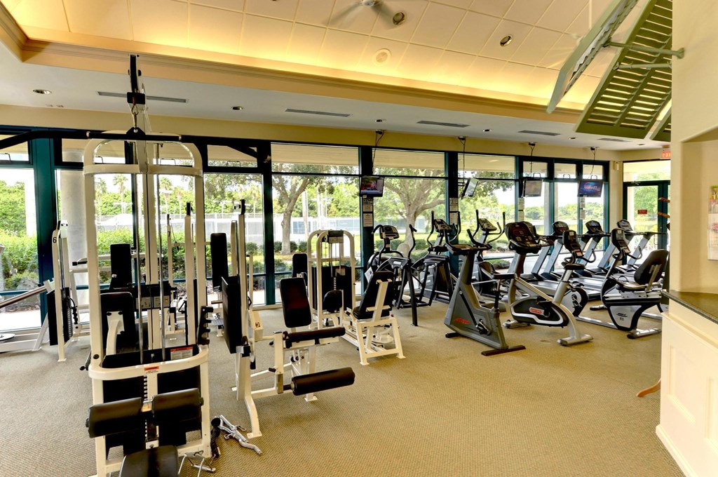a gym with a lot of exercise equipment and windows