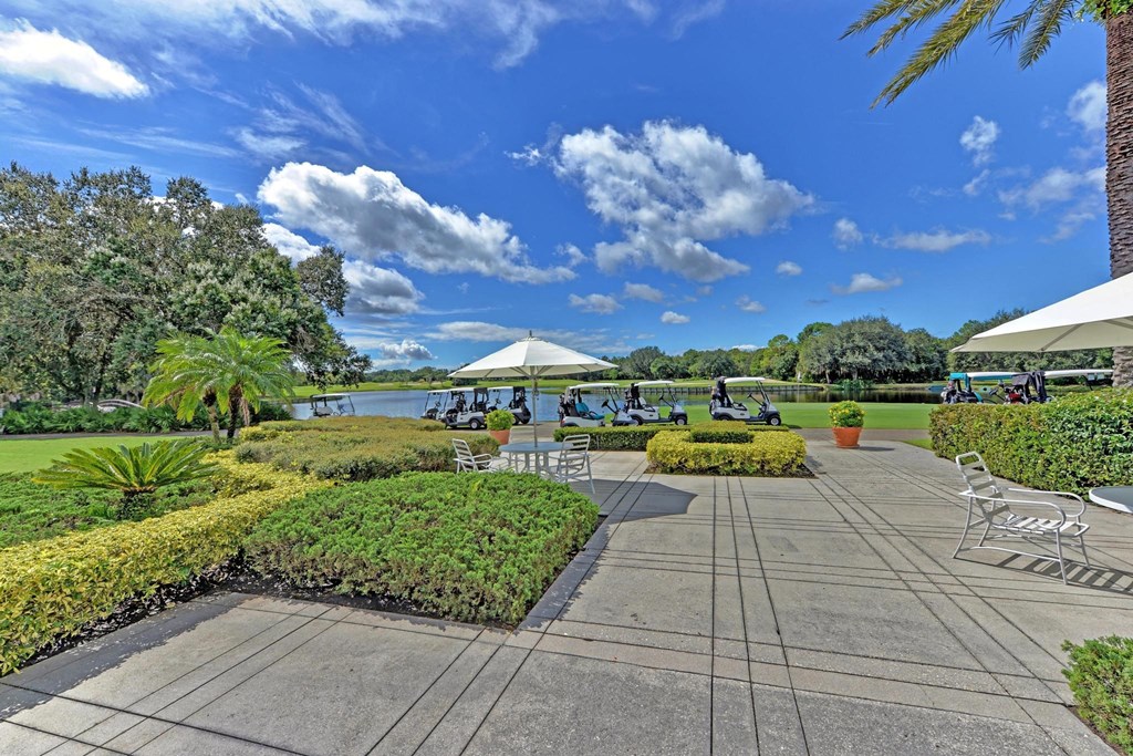 a view of a park with tables and chairs and a lake