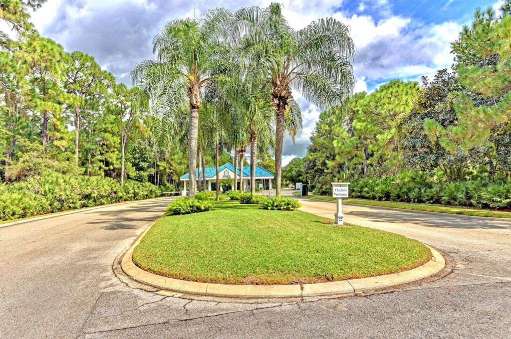 a roundabout in a park with palm trees and a sign