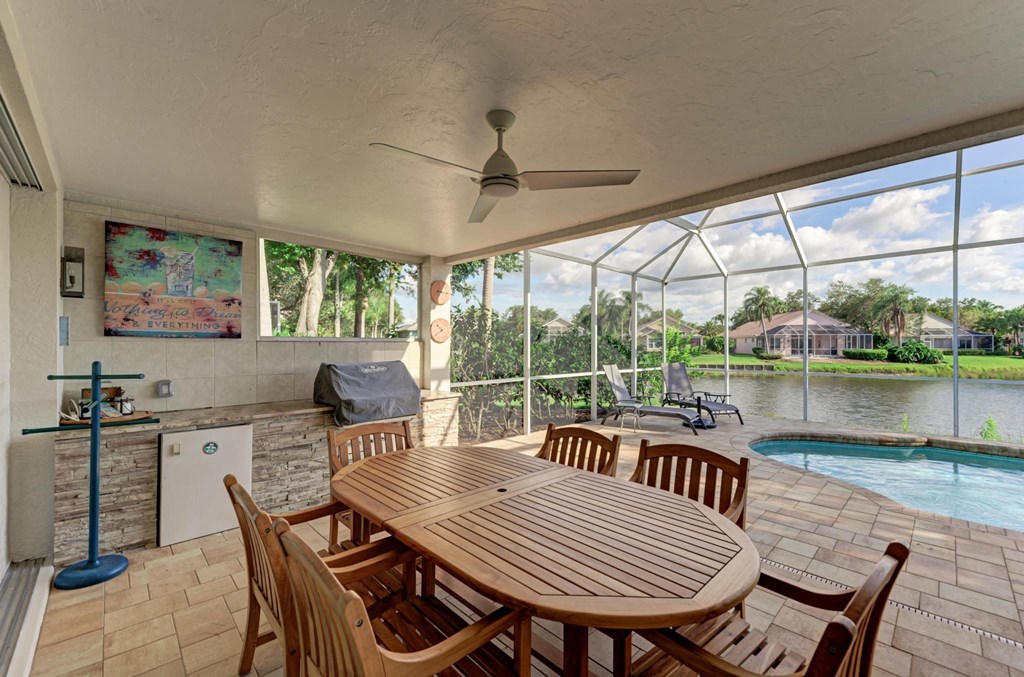 a patio with a table and chairs and a swimming pool