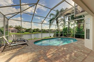 a porch with a swimming pool and a patio with chairs