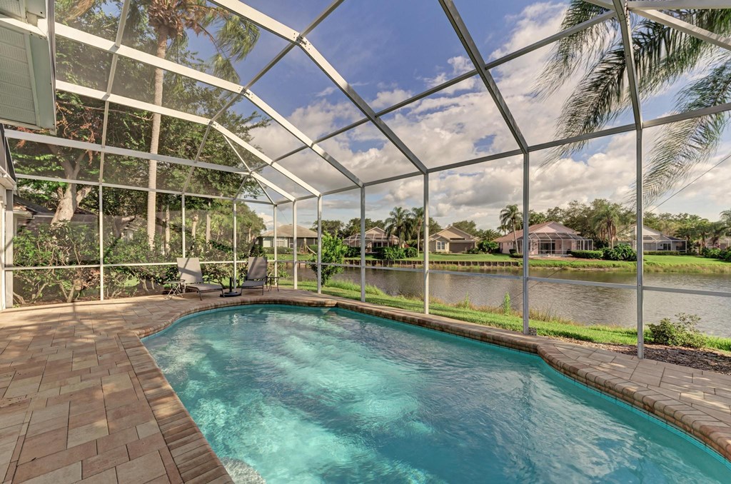 the pool is under a glass roof and next to a body of water