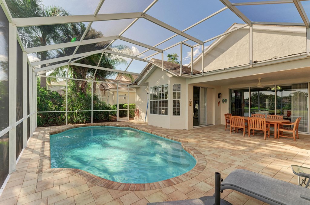 the pool is under a glass roof and next to a patio