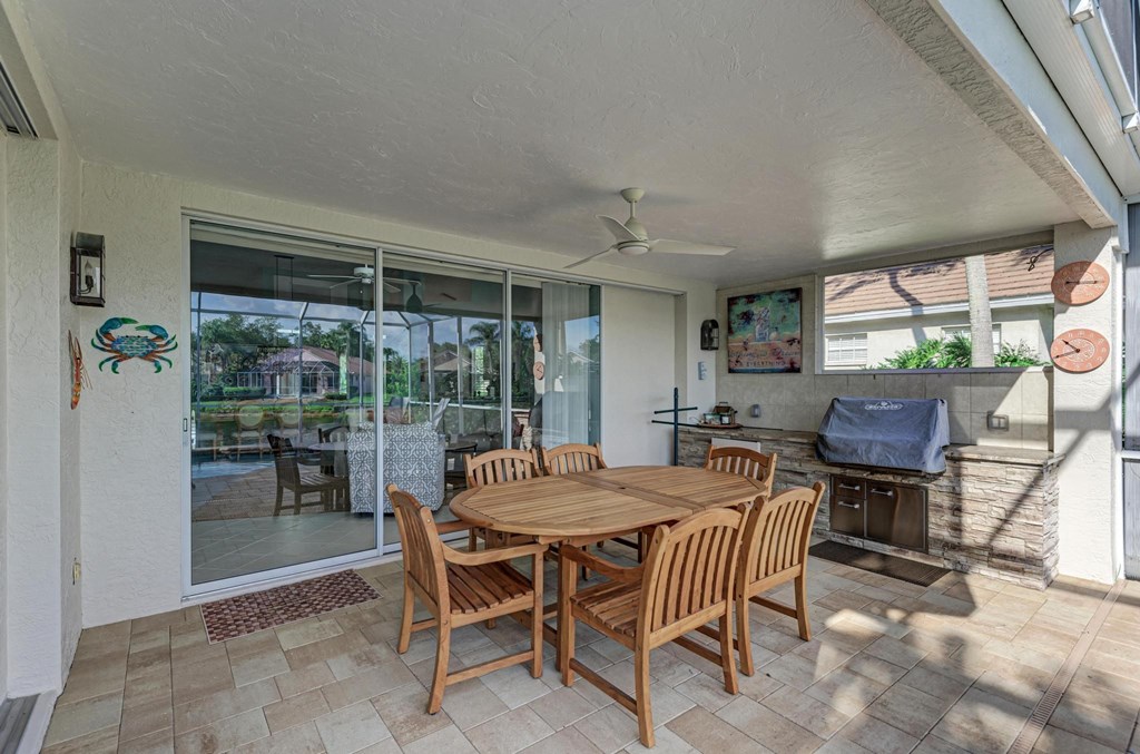 a dining area with a table and chairs and sliding glass doors
