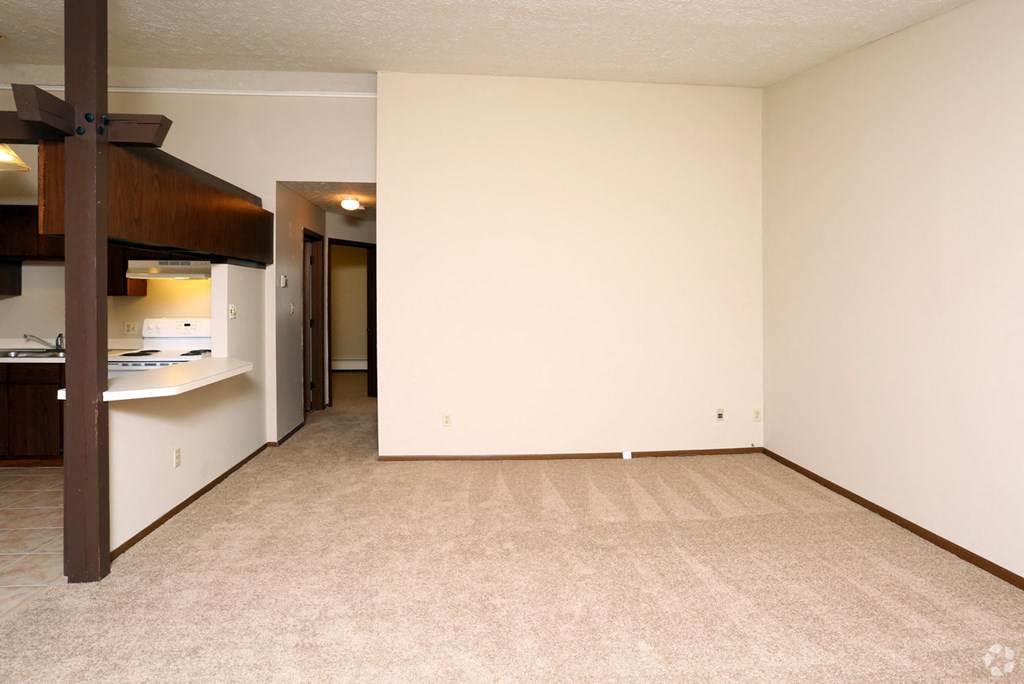 an empty living room with a kitchen and a bunk bed