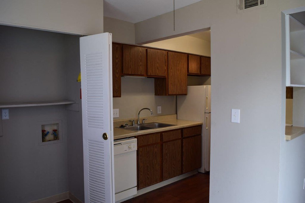 an empty kitchen with a sink and a refrigerator