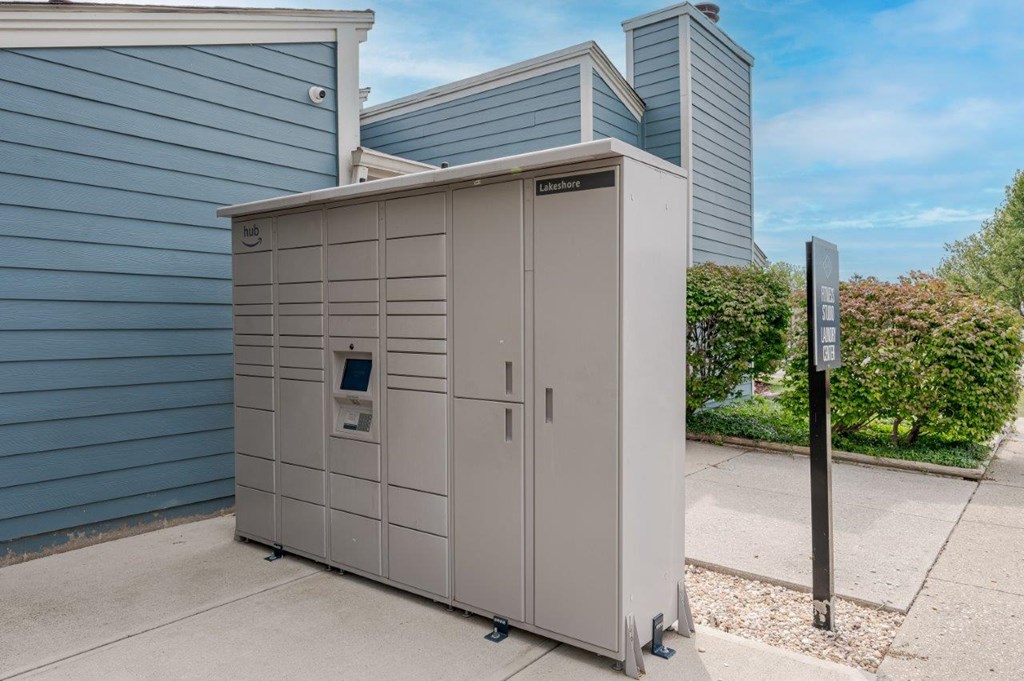 a small shed with a parking meter in front of a blue building