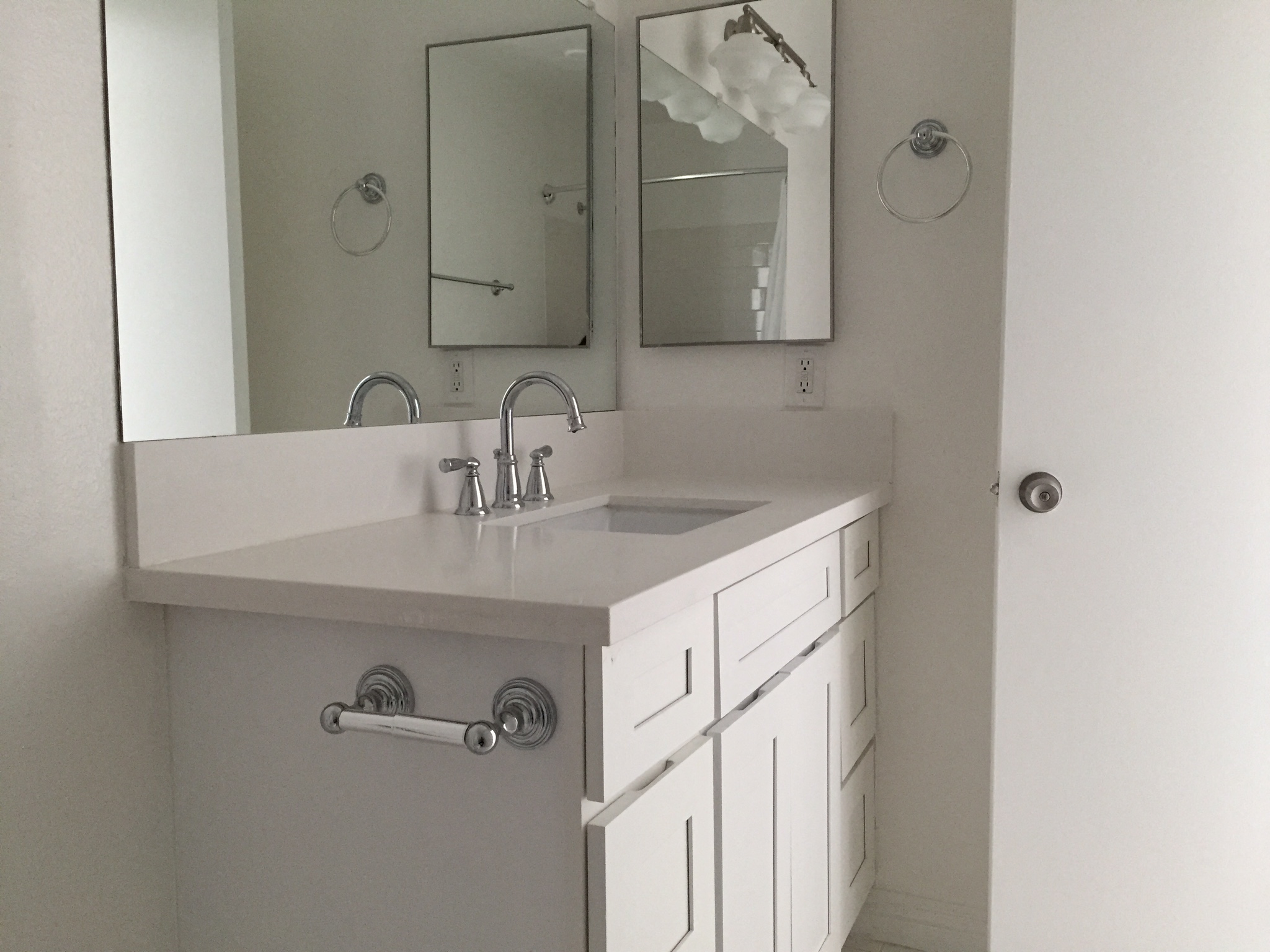 a white bathroom with a sink and a mirror