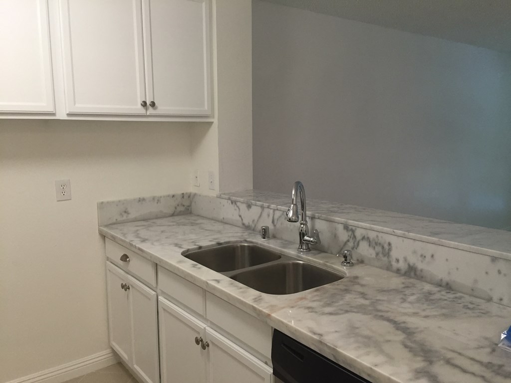 a kitchen with marble counter tops and a sink