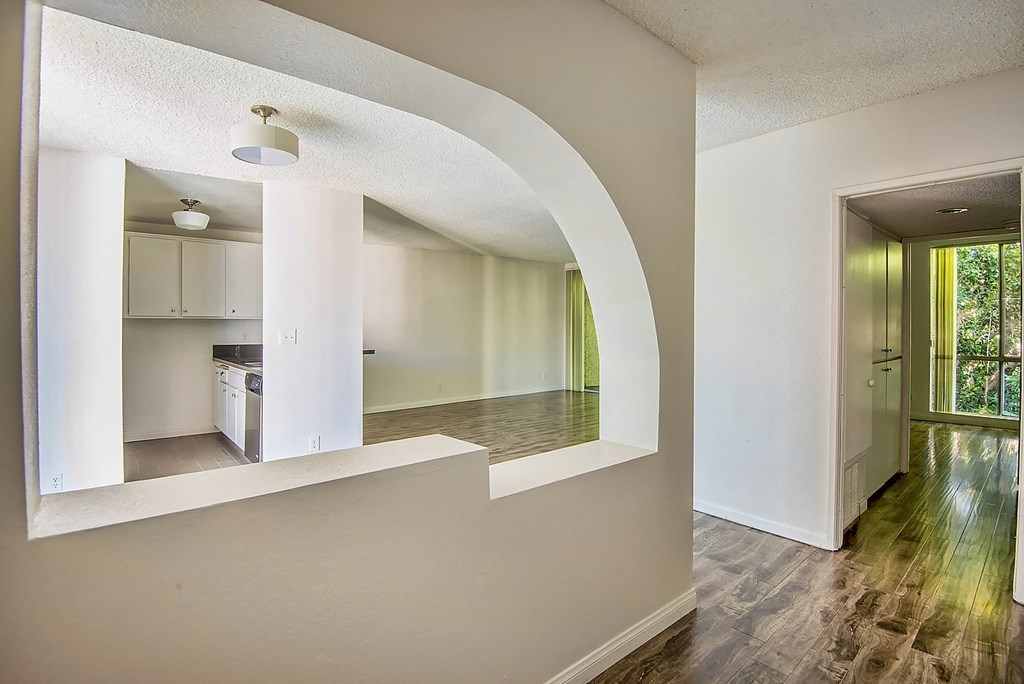 an open kitchen and living room with a hard wood floor
