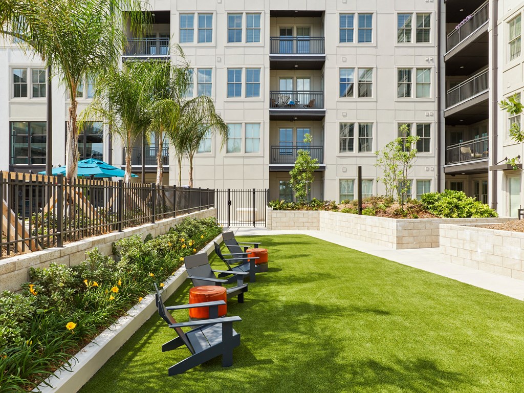 an outdoor seating area with benches in front of an apartment building