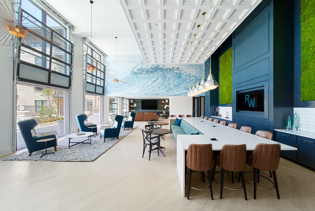 the lobby of a building with a large communal table and chairs