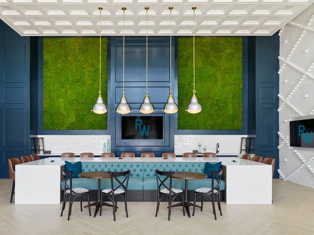 a blue and white bar with blue chairs and a television in a room with grass