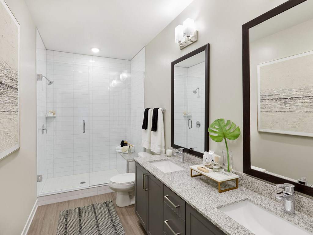a white bathroom with a large mirror and a toilet