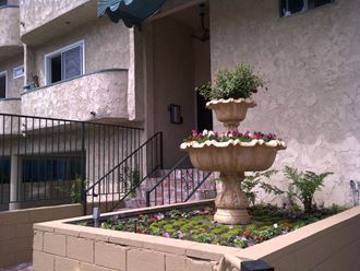 a flower garden in front of an apartment building
