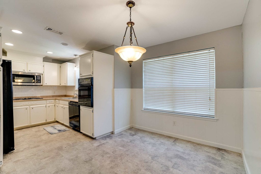 the kitchen and dining room of a home with a large window