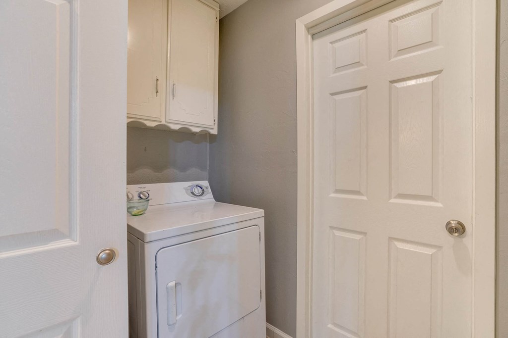 a small laundry room with a washer and dryer and a white door