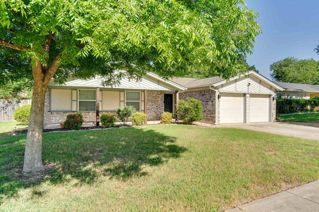 a house with a lawn and a tree in front of it