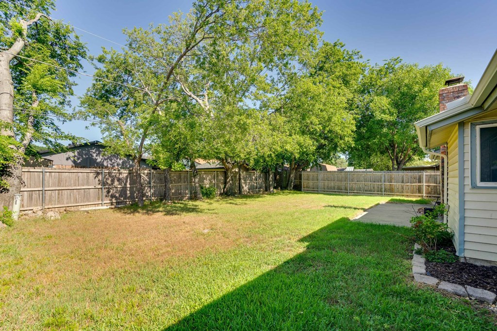 the backyard of a house with a yard and a fence