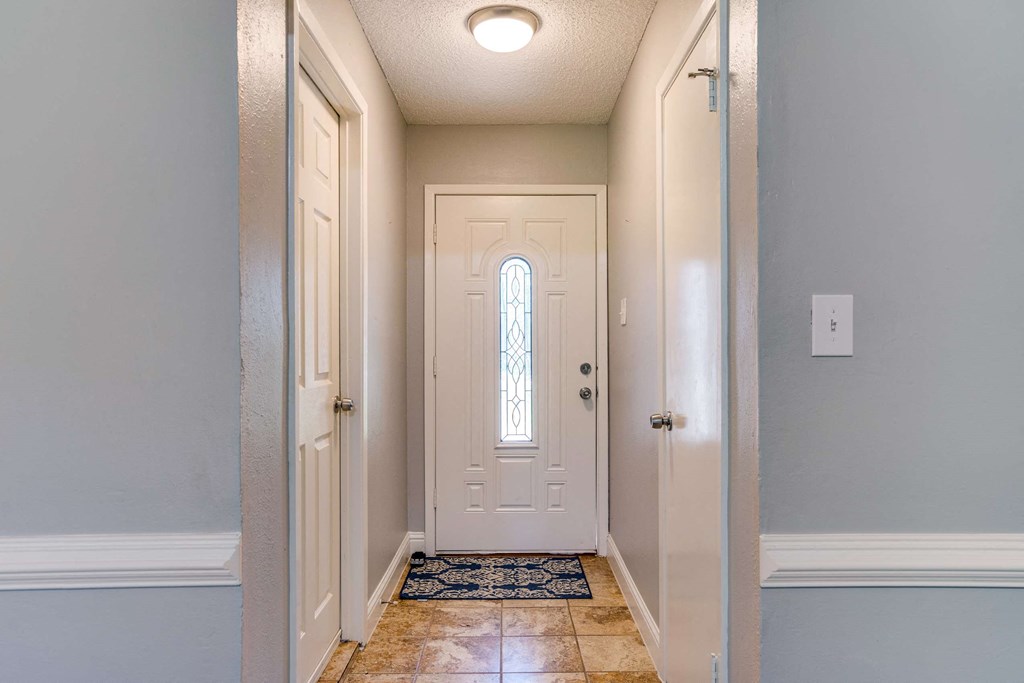 a hallway with a white door and a window