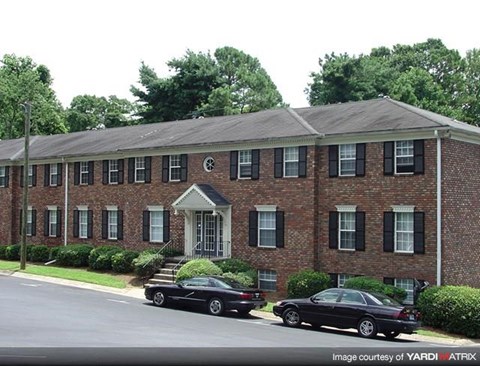 a brick building with two cars parked in front of it