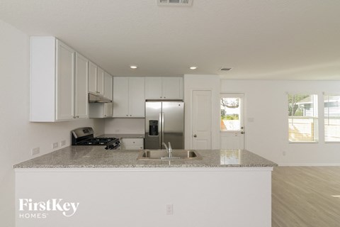 a kitchen with white cabinets and a granite counter top