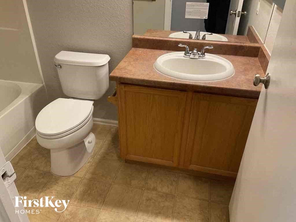 a bathroom with a toilet and a sink and a mirror