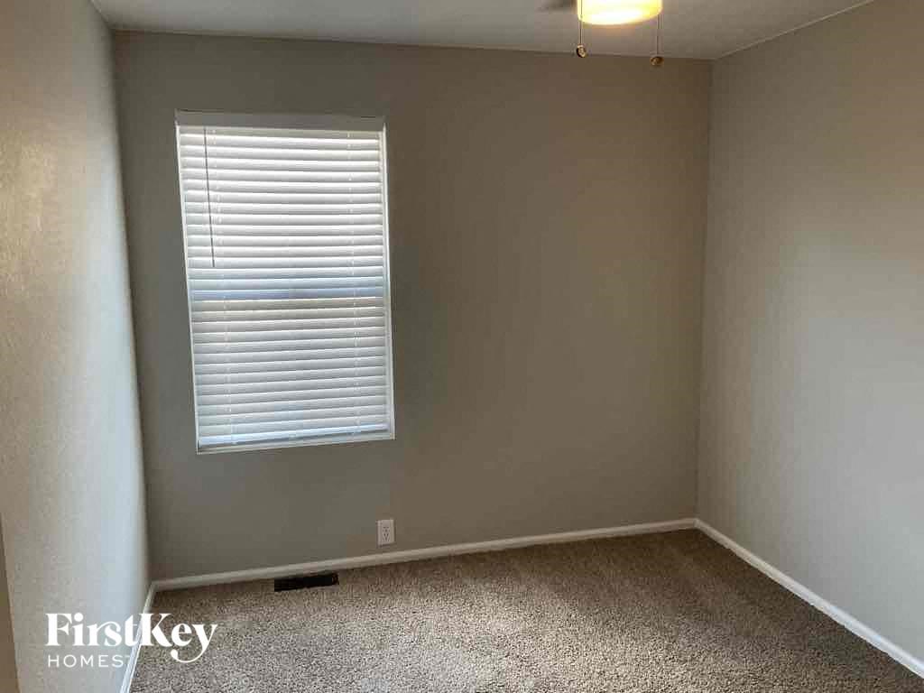 a empty room with a window and a lamp on the ceiling