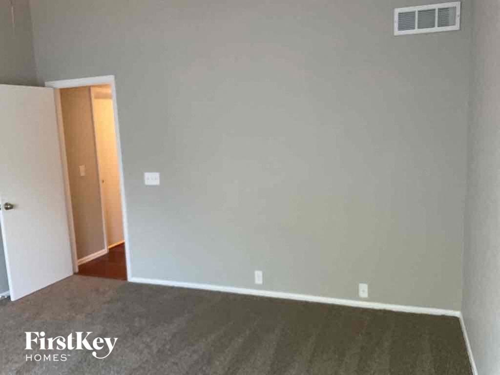 an empty living room with a door to a closet