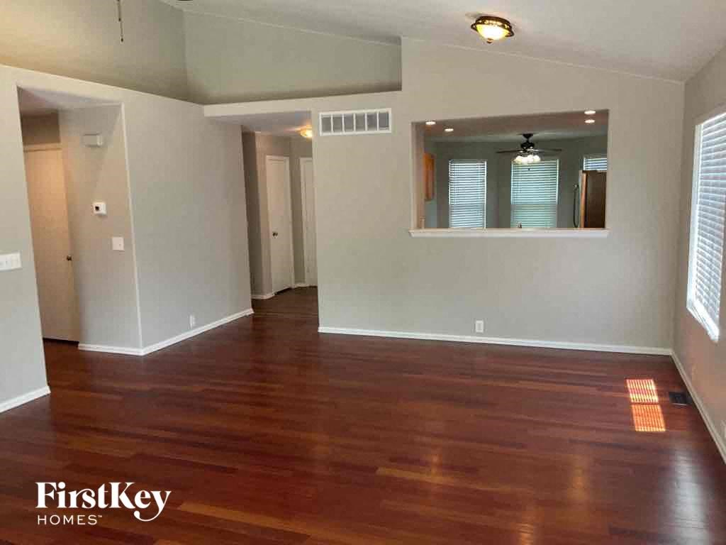 an empty living room with wood flooring and white walls