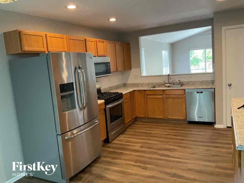 a kitchen with wooden floors and stainless steel appliances