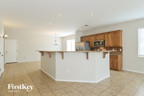A kitchen with a white counter and wooden cabinets.