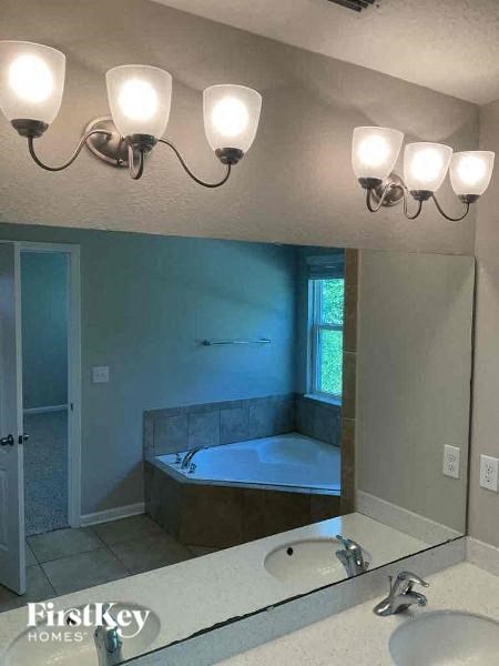 a bathroom with a tub and a sink and a mirror