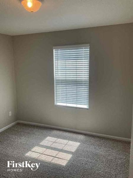 an empty room with a window and a light on the ceiling