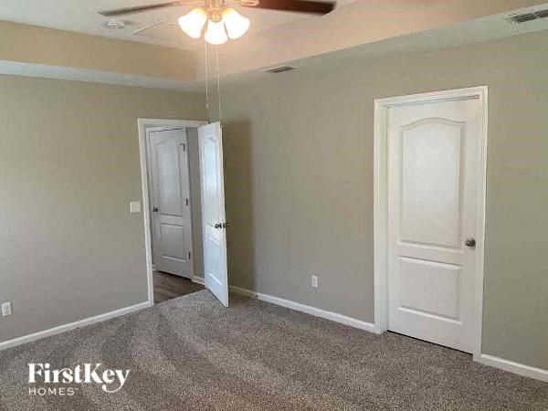 a empty room with two doors and a ceiling fan